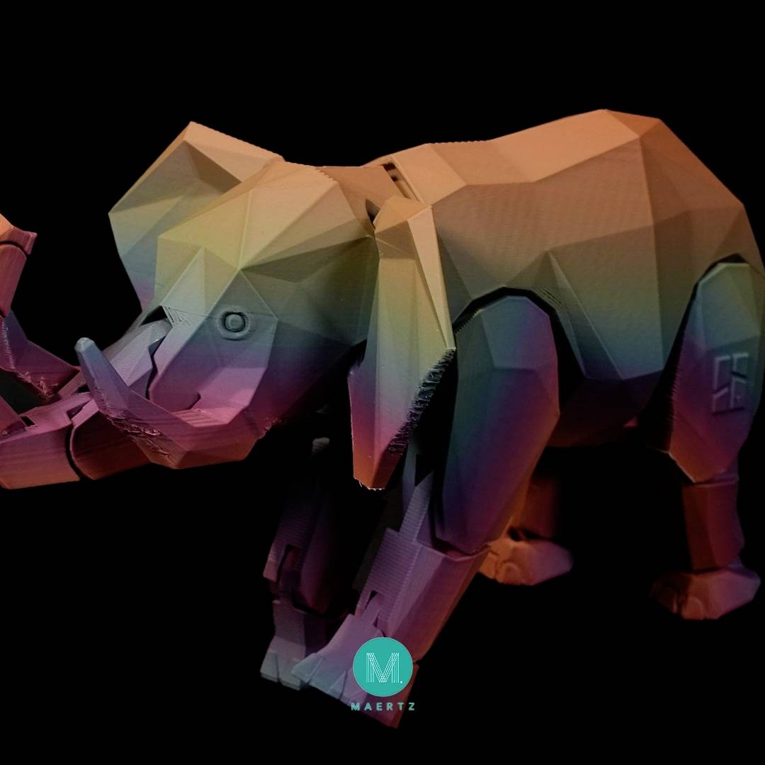 Ein geometrisch gestalteter Elefant in bunten Schattierungen steht auf einem schwarzen Hintergrund. Im Vordergrund sind keine weiteren Objekte.