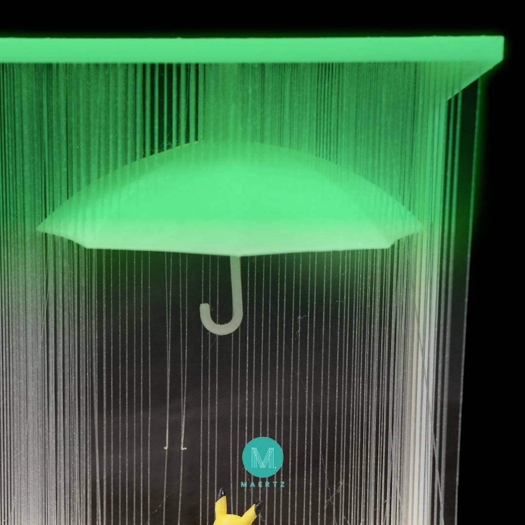 Ein nachtleuchtender Regenschirm übergießt einen gelben Haken. Im Hintergrund ist ein schwarzer Raum mit tropfenden Lichtschnüren.