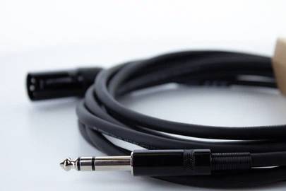 Ein schwarzes Audiokabel mit einem 3,5-mm-Stereo-Klinkenstecker und einem XLR-Stecker, verwendet für professionelle Audioverbindungen.