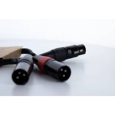 Drei XLR-Kabelstecker auf einer weißen Oberfläche. Zwei Stecker zeigen nach vorne, während ein Stecker nach hinten zeigt.
