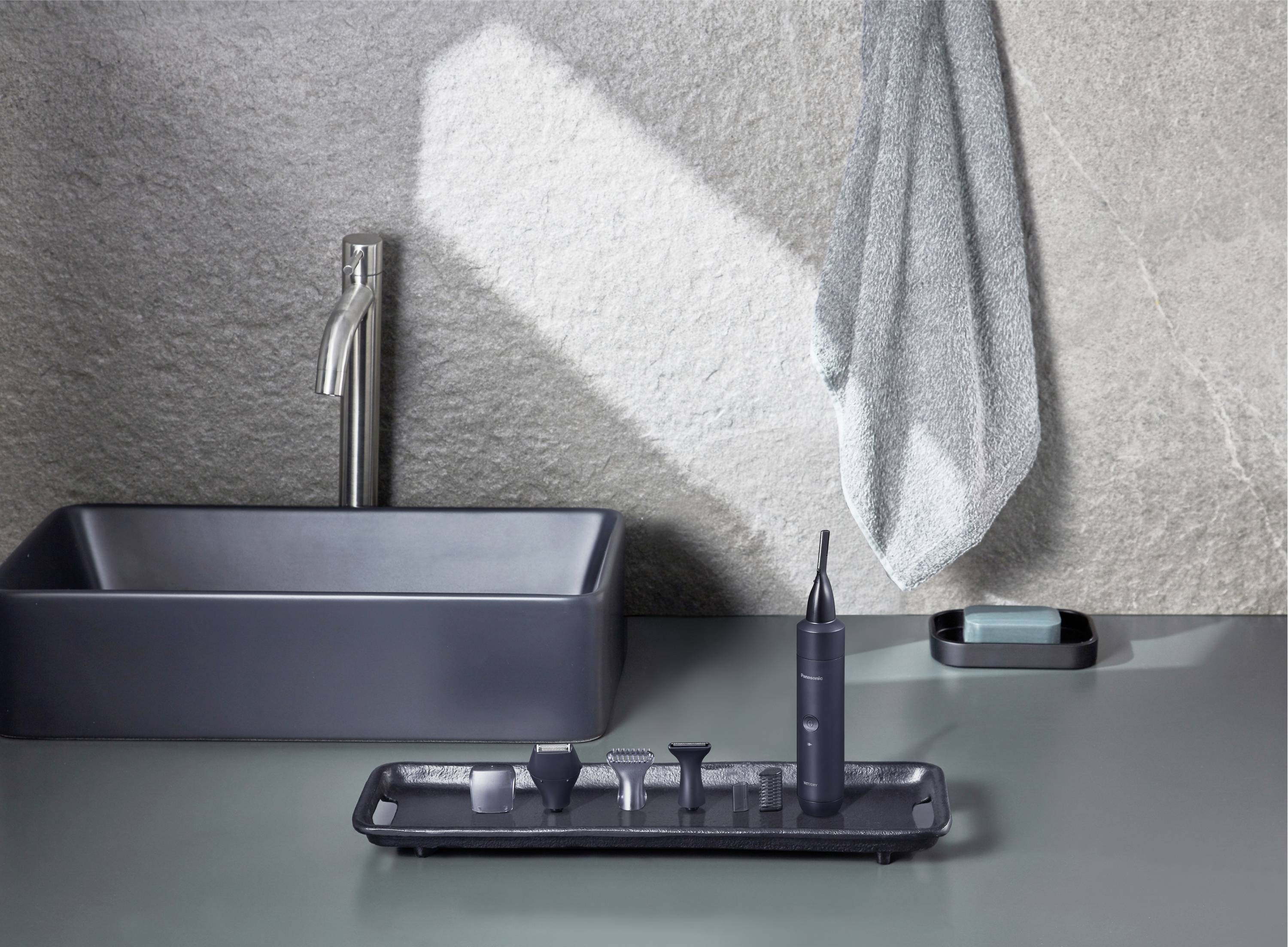 Ein stilvoll eingerichtetes Badezimmer mit einem modernen Waschbecken, einem Zahnreinigungsgerät und Handtuch, das an der Wand hängt.