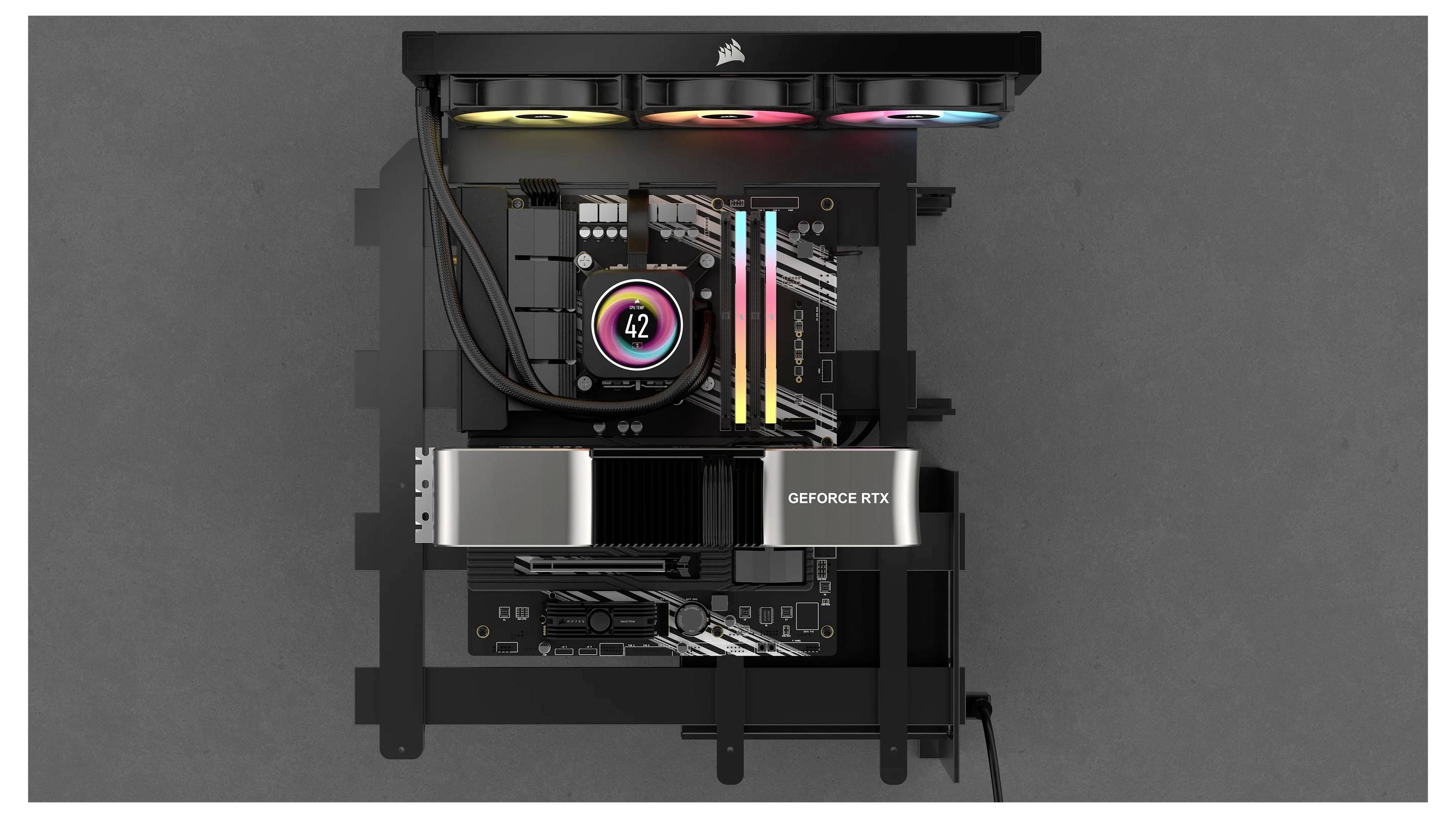 Computer-Motherboard von oben mit beleuchtetem Lüfter, drei RAM-Modulen und einer Grafikkarte mit 'GEFORCE RTX'-Beschriftung.