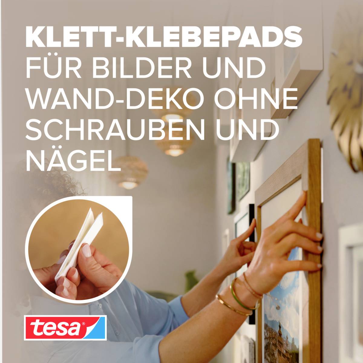 Person hängt ein Bild an eine Wand mit 'tesa'-Klettpads. Text: "Klett-Klebepads für Bilder und Wand-Deko ohne Schrauben und Nägel".