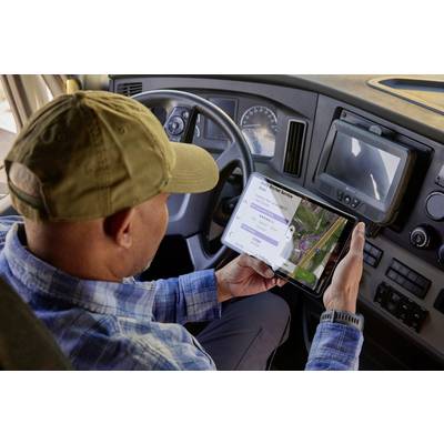 Mann in LKW-Fahrerkabine nutzt Tablet mit Navigations- und Bewertungs-App. Trendige Technologie in der Logistikbranche.