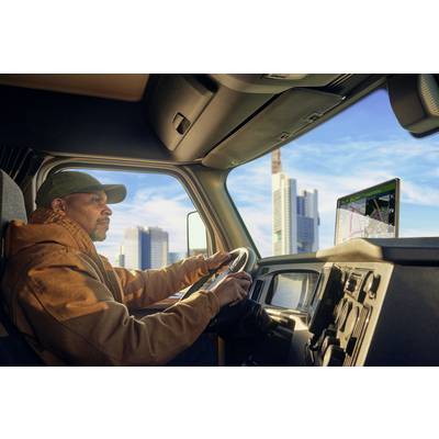 Ein Mann fährt einen LKW durch eine Stadt, konzentriert auf die Straße. Auf dem Armaturenbrett ist ein GPS-Navigationsbildschirm sichtbar.