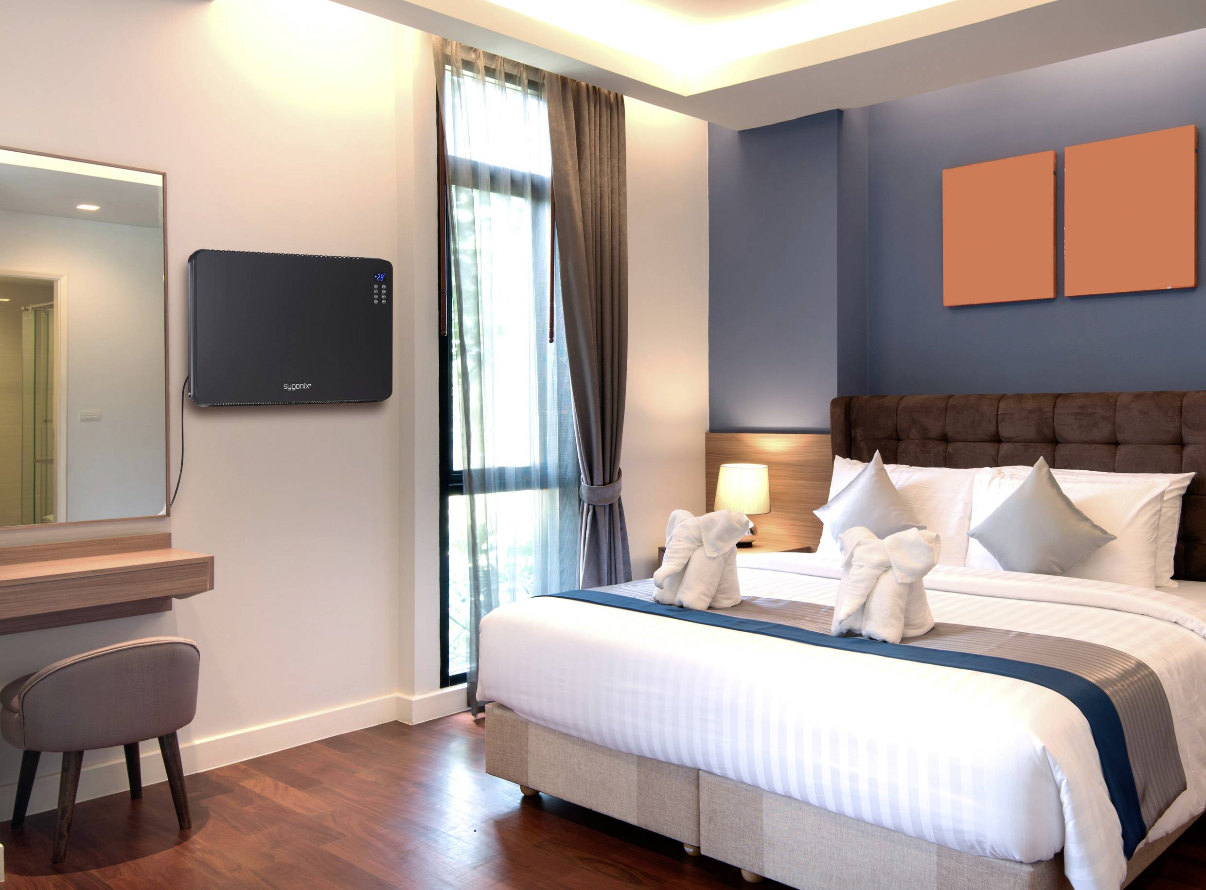 Ein modernes Hotelzimmer mit einem Doppelbett, zwei gefalteten Handtüchern in Schwanenform auf dem Bett, und einem Schreibtisch mit Spiegel.