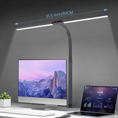 Ein moderner Arbeitsplatz mit einem großen Computermonitor und einem Laptop. Eine LED-Lampe leuchtet den Bereich gleichmäßig aus.