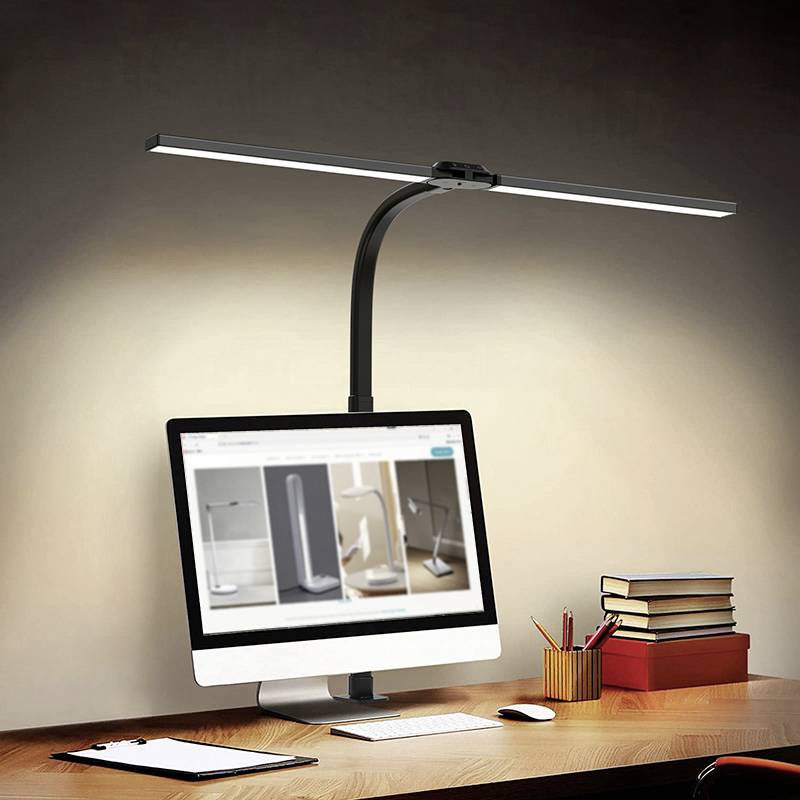 Ein Schreibtisch mit einem PC-Monitor, auf dem Lampen angezeigt werden. Über dem Monitor leuchtet eine lange, gebogene Schreibtischlampe.