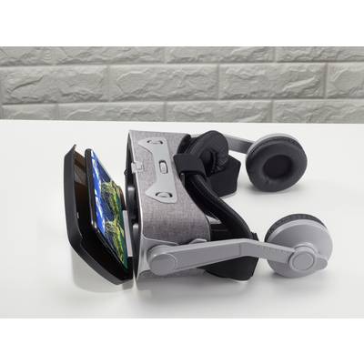 Ein VR-Headset liegt auf einem Tisch. Ein Smartphone ist in das Headset eingesteckt und zeigt eine Landschaft auf dem Display.