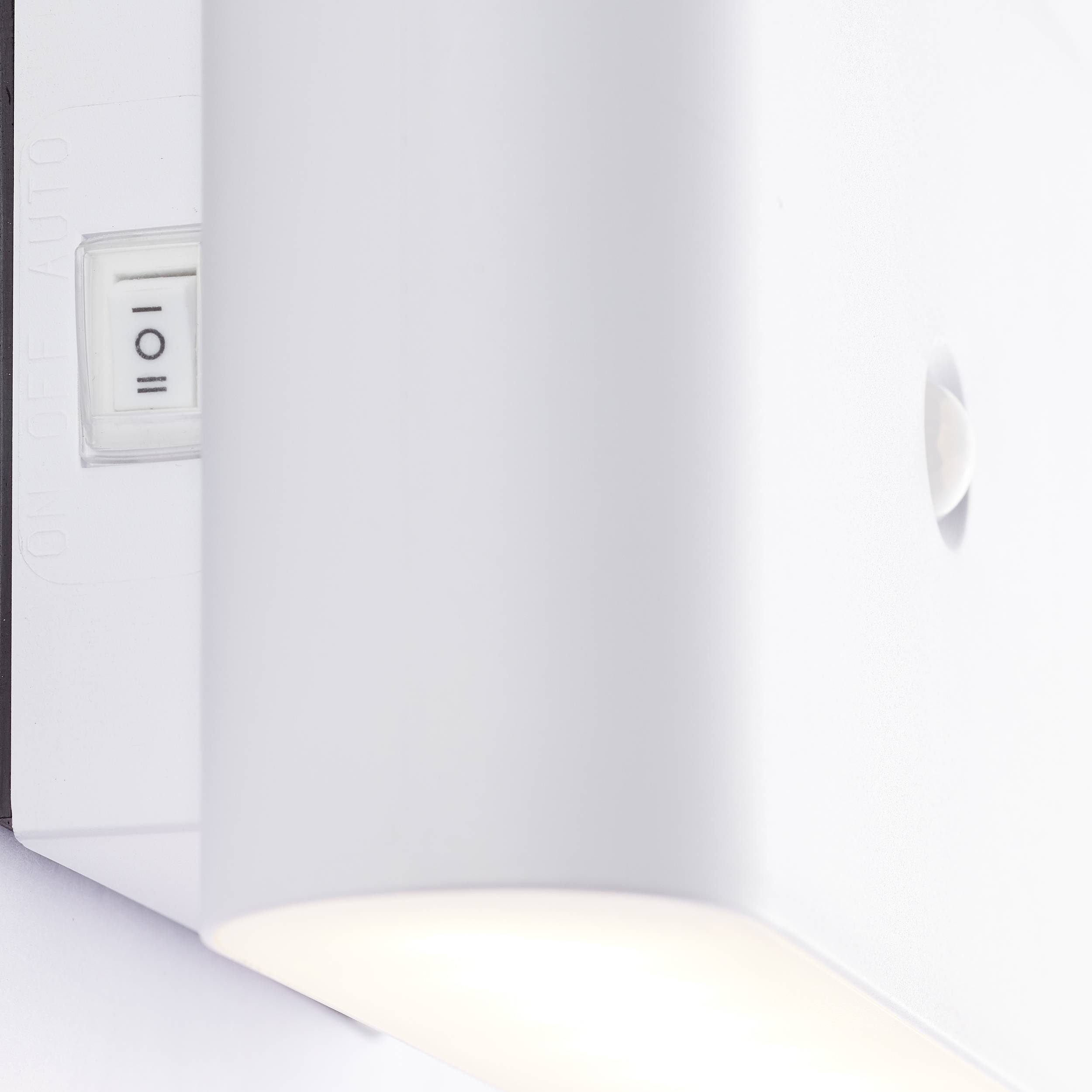 Nahaufnahme eines weißen Lichtschalters mit den Einstellungen 'On', 'Off' und 'Auto'. Der Schalter befindet sich an einem rechteckigen Gehäuse.