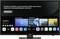 Ein Fernseherbildschirm zeigt die Startseite eines Smart-TVs mit Apps. Der Text bittet um Zustimmung zu den Allgemeinen Nutzungsbedingungen.