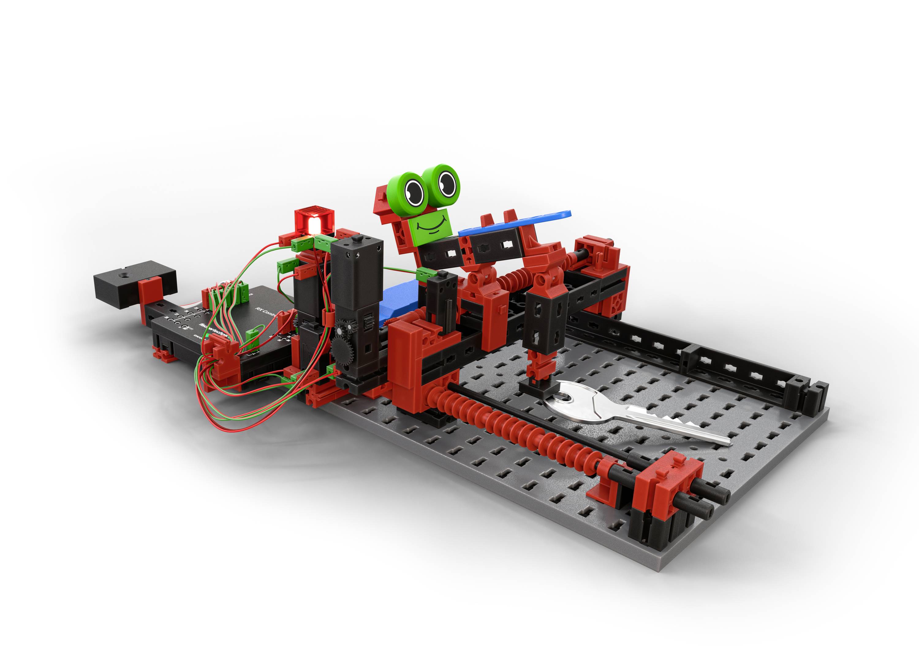 Ein Roboterbausatz aus roten und schwarzen Teilen auf einer grauen Platte. Ein 'Gesicht' mit grünen Augen zeigt mechanische Bewegung.