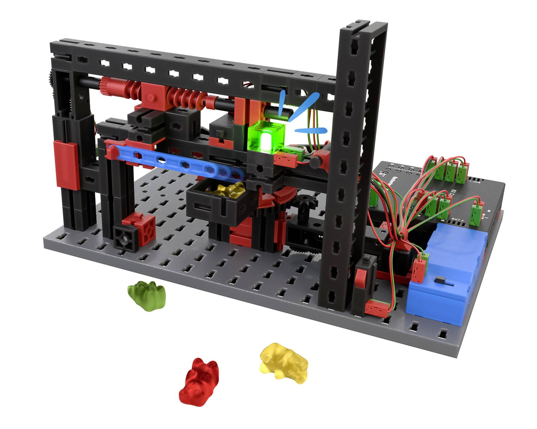Modell eines automatisierten Systems aus bausteinartigen Teilen, mit verdrahteter Elektronik und bunten Gummibärchen auf dem Tisch.