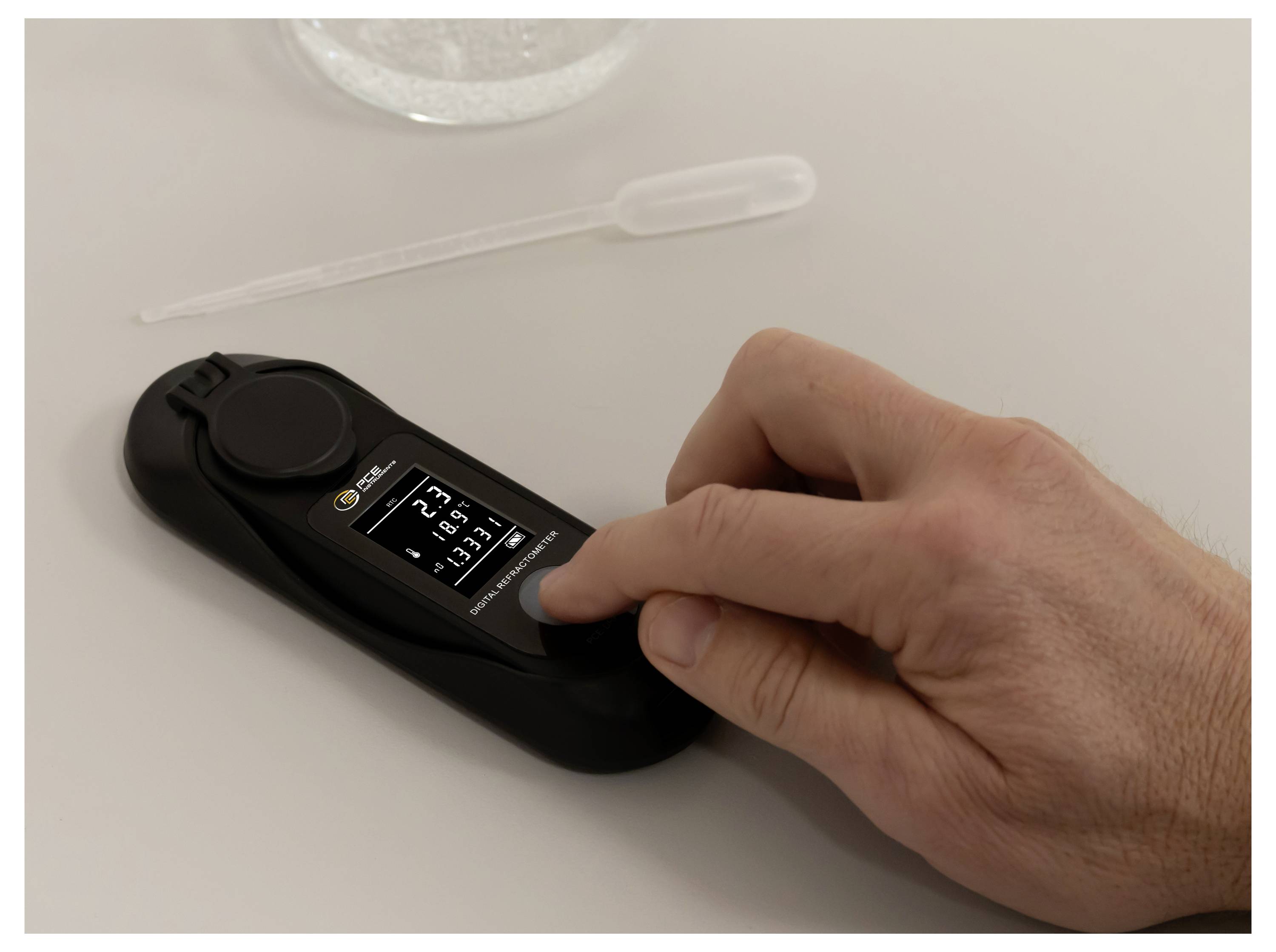 Eine Hand benutzt ein schnelles HIV-Testgerät auf einem Tisch, mit einer Pipette in der Nähe und das Ergebnis auf dem Bildschirm angezeigt.