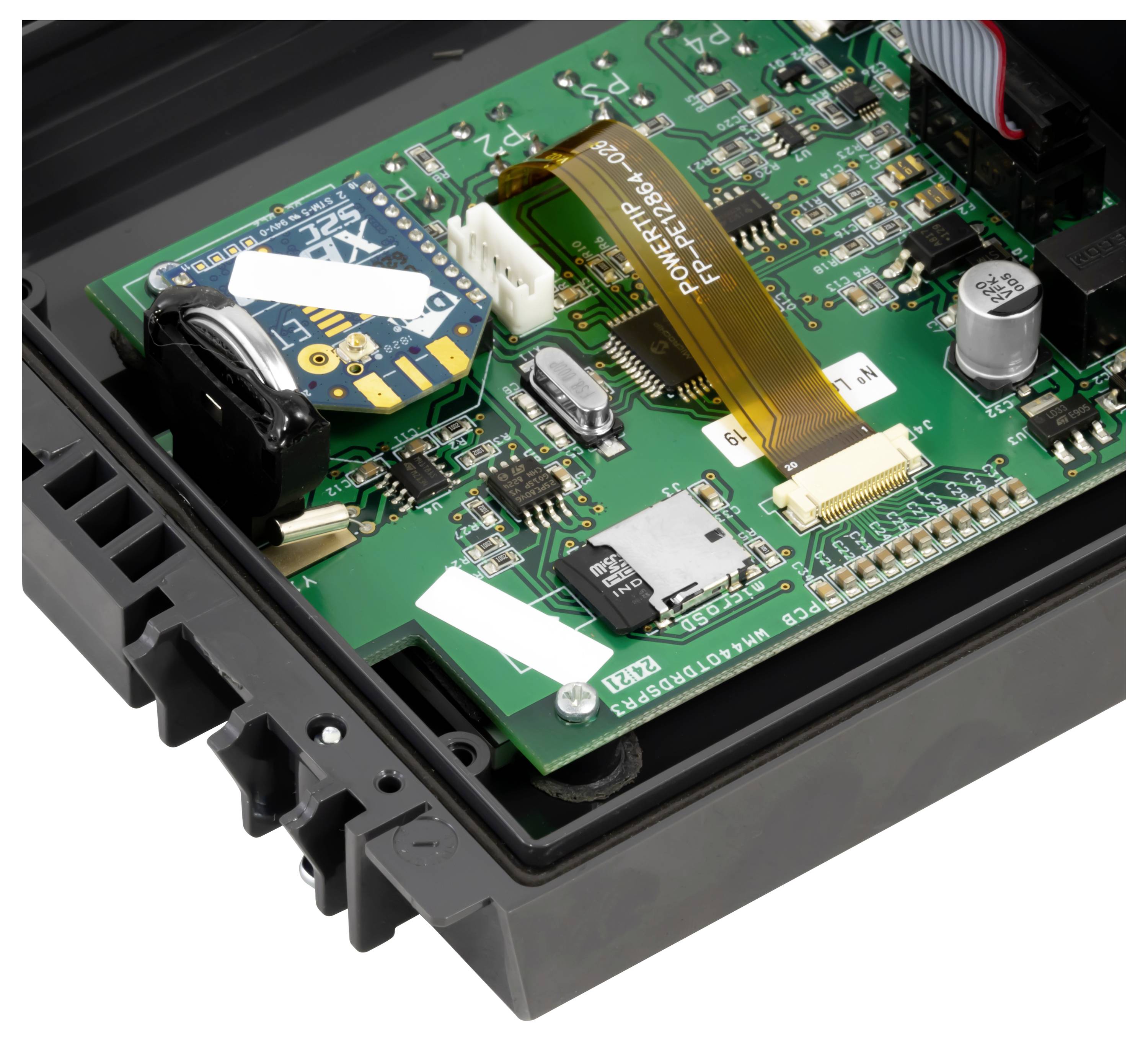Offenes elektronisches Gerät mit einer grünen Leiterplatte mit Flachbandkabel, Steckverbindern, Chips und einem schwarzen Kunststoffgehäuse.