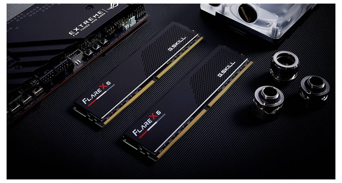 Zwei RAM-Module von G.SKILL mit der Aufschrift 'FLARE X5', neben Computerkomponenten, auf einer mattschwarzen Oberfläche.
