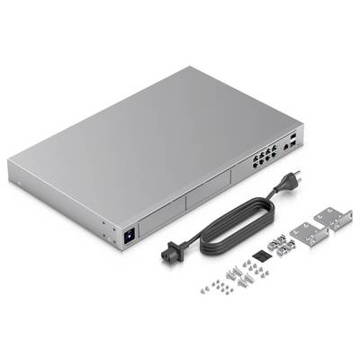 Silberfarbener Netzwerk-Switch mit mehreren Ethernet-Anschlüssen, Netzadapter, Montageklemmen und Schrauben, alles auf weißem Hintergrund.