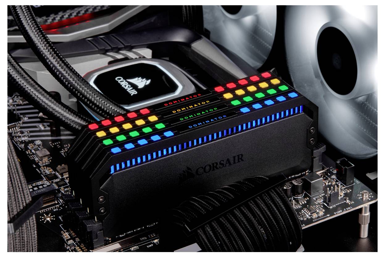 'Leuchtender RAM-Speicher mit RGB-Beleuchtung auf einem Computer-Motherboard, umgeben von Lüftern und Kabeln.'