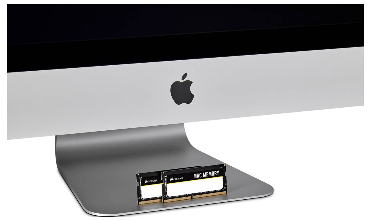 Ein iMac steht auf einem Tisch, darunter liegen zwei RAM-Module.