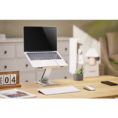 Ein moderner Schreibtisch mit Laptop auf einem Ständer, Tastatur, Maus, Kalender mit Datum 'Jul 04', Smartphone und einer kleinen Pflanze.