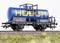 Ein blauer Güterzugtankwagen mit gelber Aufschrift 'HOBUM' steht auf Gleisen. Detaillierte Beschriftungen und Leitern sind sichtbar.