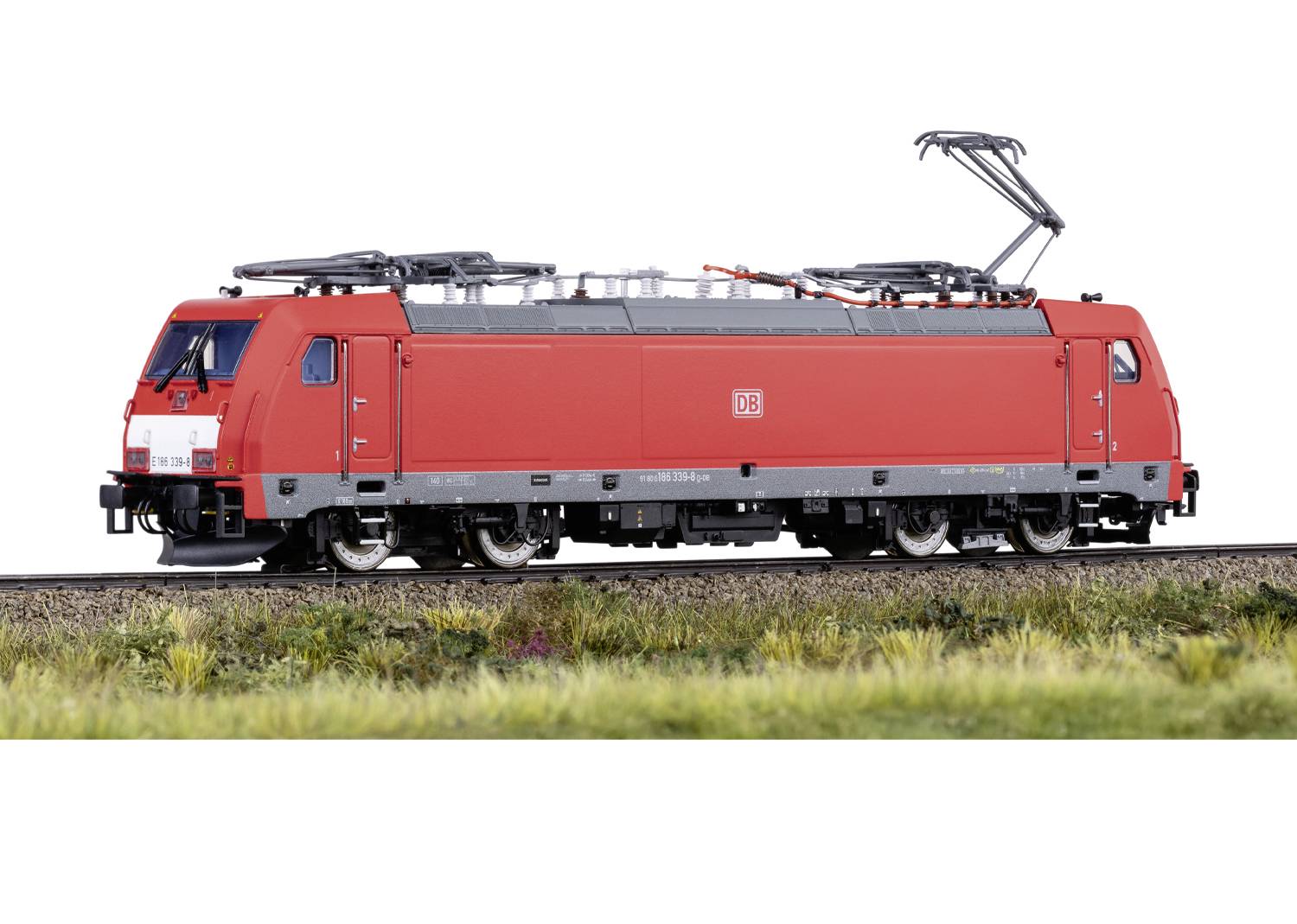Roter Elektrolokomotive mit DB-Logo auf Schiene vor grünlichem Hintergrund, seitliche Ansicht.