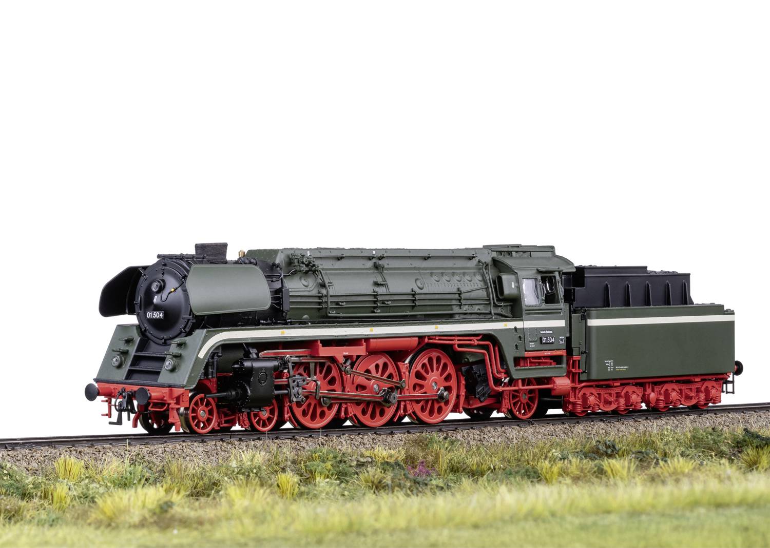 Ein Modell einer grünen Dampflokomotive mit roten Rädern auf einem Gleis, umgeben von Gras. Die Lokomotive hat eine detaillierte Gestaltung.
