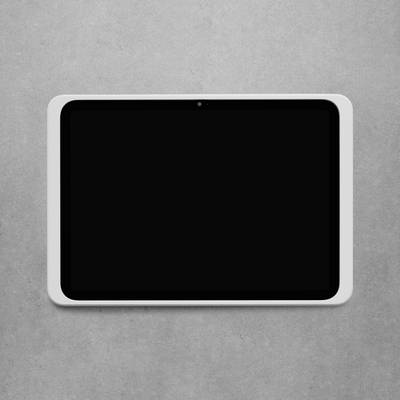Eine schwarze, rechteckige Tafel mit weißem Rahmen hängt an einer grauen Wand. Sie sieht aus wie ein modernes, technisches Gerät.