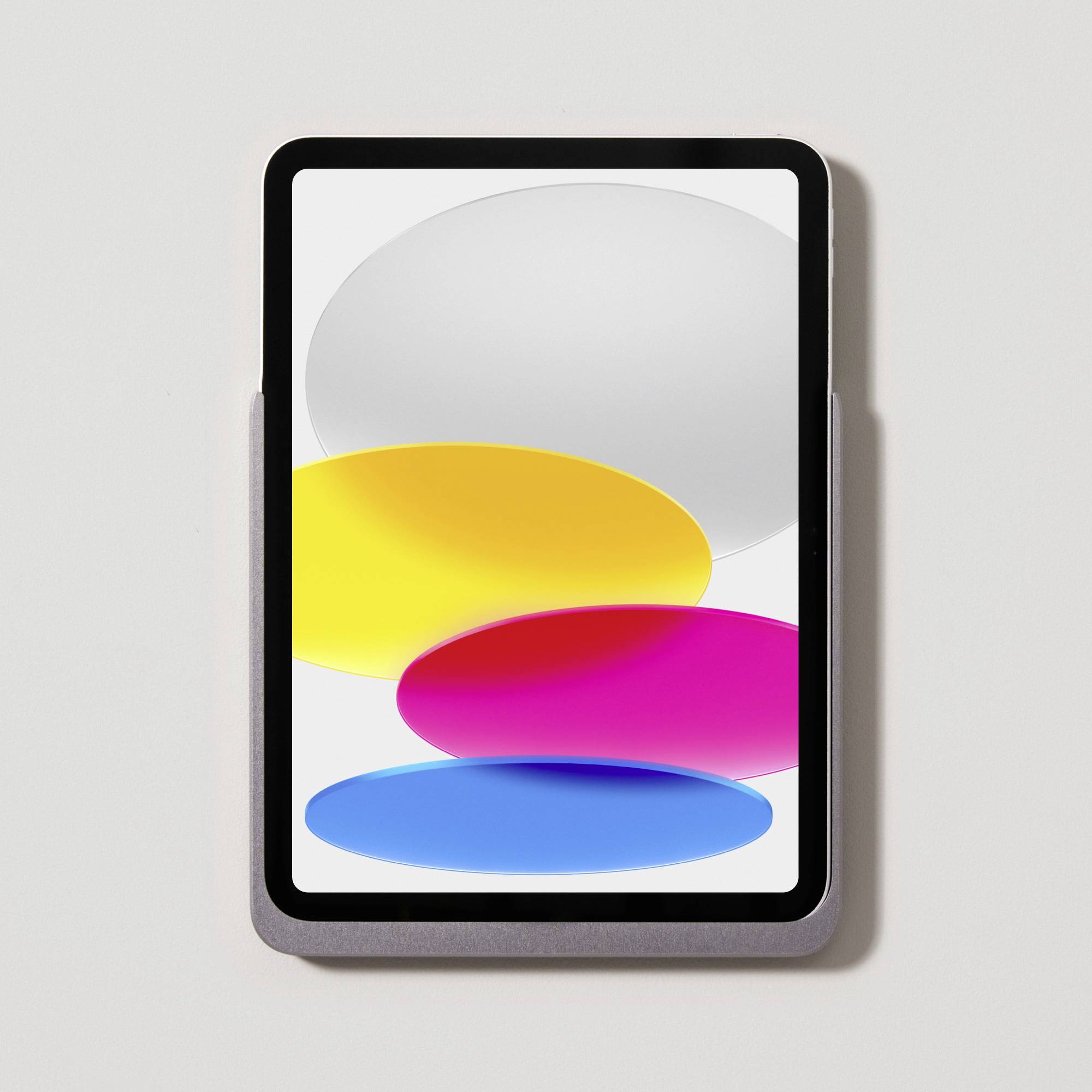 Tablet mit Display, das bunte geometrische Formen zeigt: ein weißes Oval oben, darunter gelbe, rote und blaue ovale Formen.