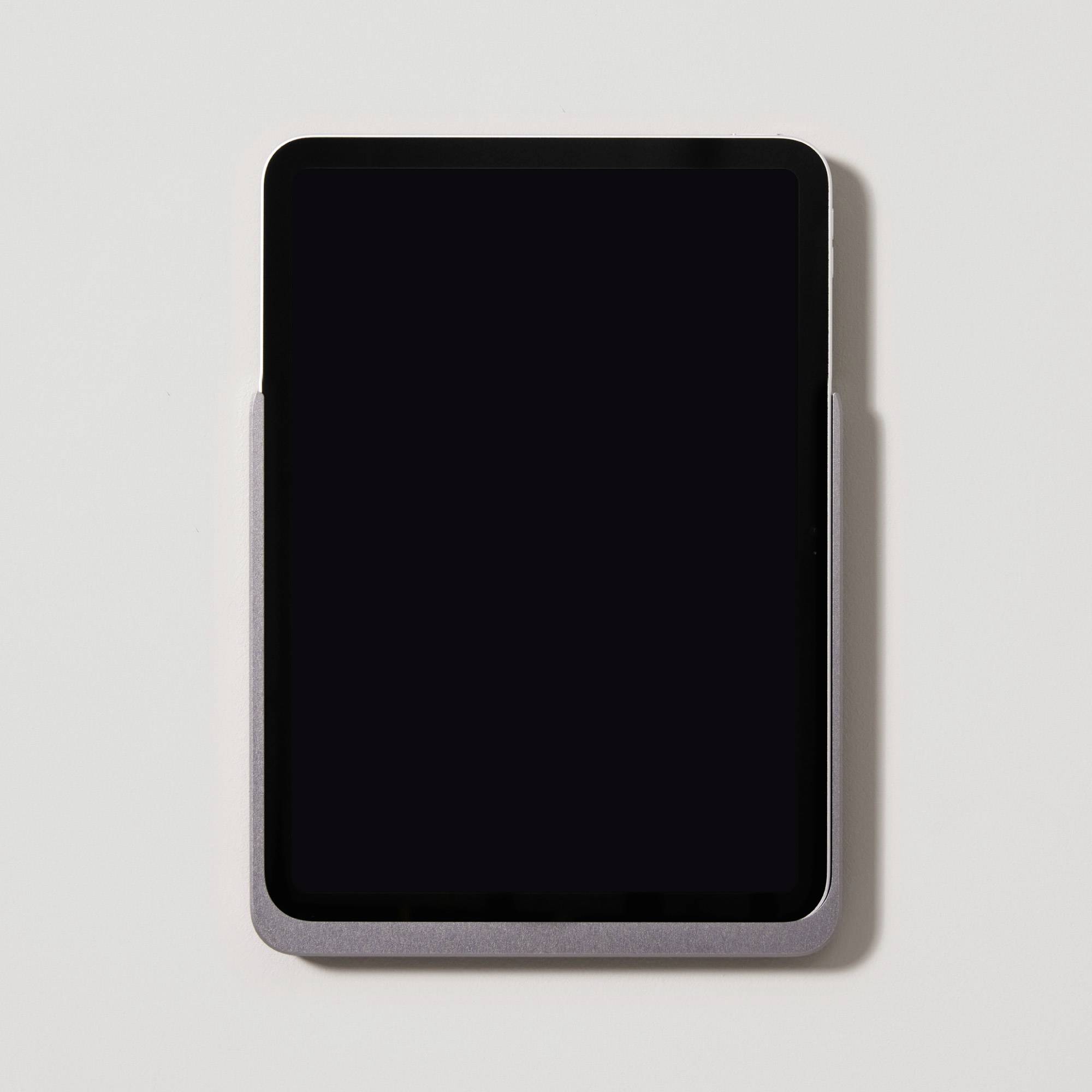Ein schwarzes Tablet, das in einer grauen Hülle aufrecht steht, vor einem weißen Hintergrund.