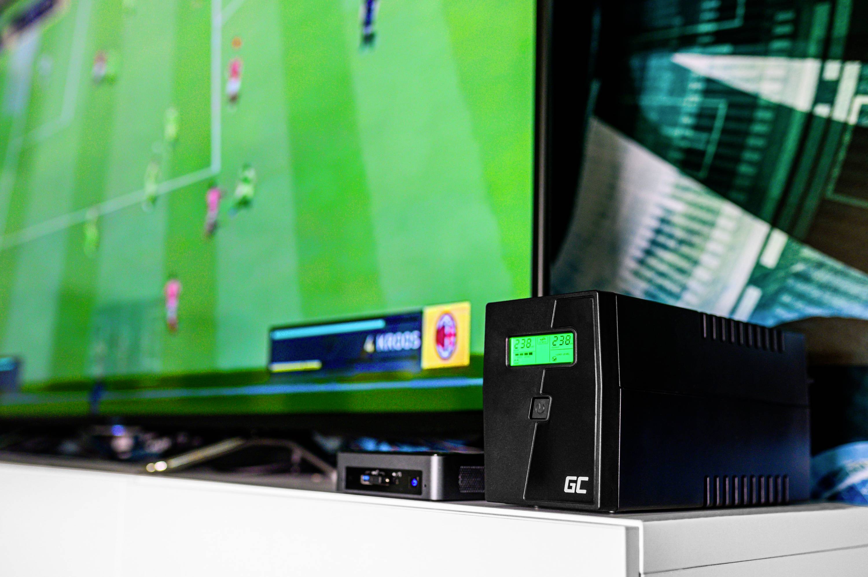 Ein Fernseher zeigt ein Fußballvideospiel. Daneben steht eine unterbrechungsfreie Stromversorgung (USV) mit leuchtendem Display.