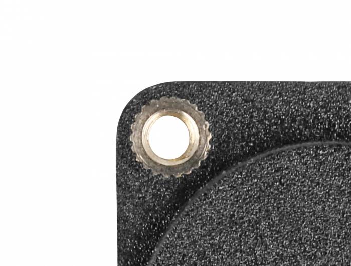 Ecke einer schwarzen strukturierten Metalloberfläche mit sichtbarer Schraubenöffnung oben links.