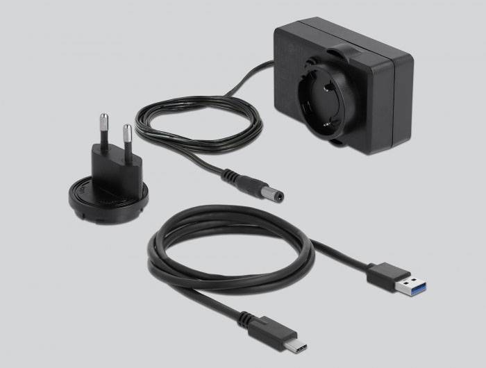 Ein schwarzes Netzteil mit austauschbarem Steckeradapter und zwei Kabeln: ein USB-A-auf-USB-C-Kabel und ein Kabel mit Rundstecker.