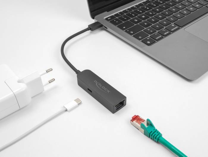Ein Laptop ist mit einem Ethernet-Adapter verbunden, der ein Ethernet-Kabel und einen Ladeanschluss zeigt.