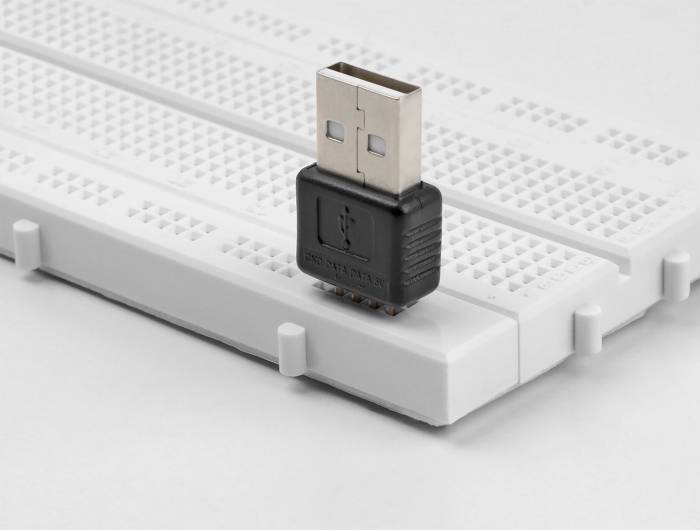 Ein USB-Adapter steckt auf einem Steckbrett, das für elektronische Prototypen verwendet wird.