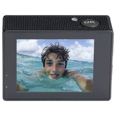 Ein Junge macht ein Selfie im Meer mit einer Action-Kamera, auf deren Bildschirm das Bild zu sehen ist. Er wirkt fröhlich und entspannt.