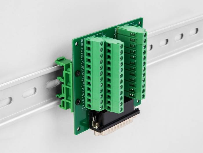 Elektronische Schaltung mit grünen Klemmen auf DIN-Schiene montiert. Verbinder für elektrische Verbindungen erkennbar.