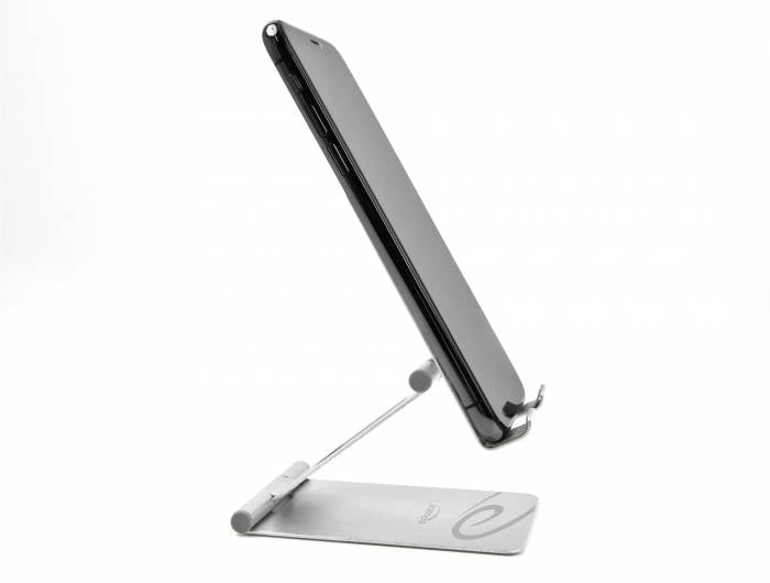 Ein schwarzes Smartphone steht aufrecht auf einem silbernen Ständer. Der Ständer hat eine verstellbare Halterung und eine beschriftete Basis.