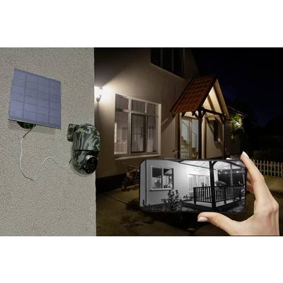 Eine Überwachungskamera an einer Hauswand, verbunden mit einem Solarpanel. Eine Hand hält ein Smartphone, das das Live-Bild zeigt.