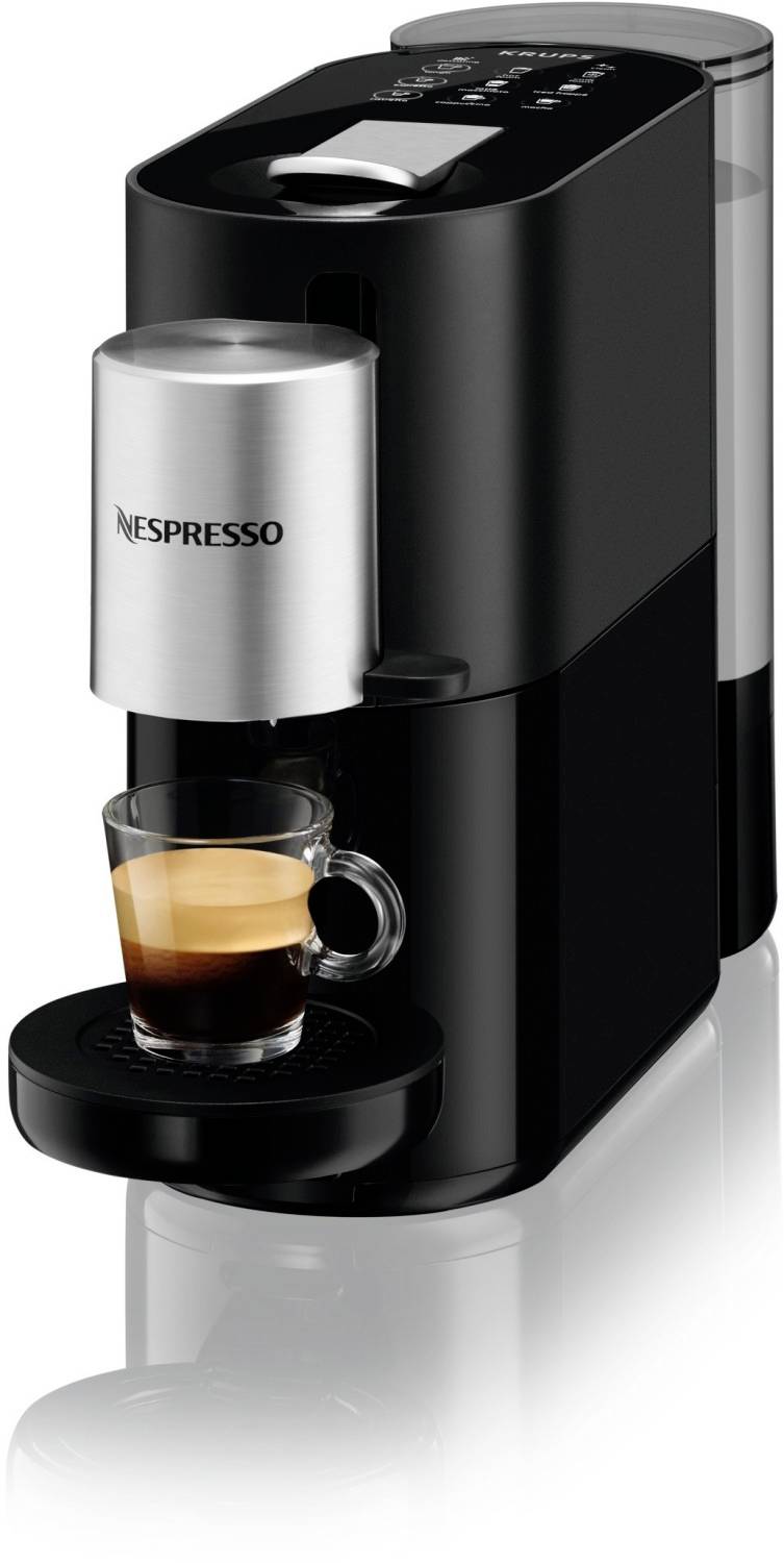 Kaffeemaschine der Marke Nespresso, schwarz, mit einer kleinen Glastasse darunter, aus der frisch gebrühter Espresso fließt.