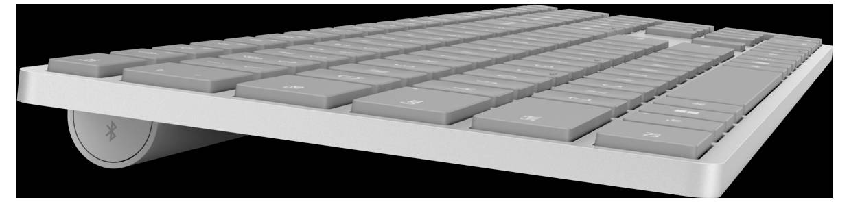 Seitliche Nahaufnahme einer modernen Tastatur in Silber auf schwarzem Hintergrund.