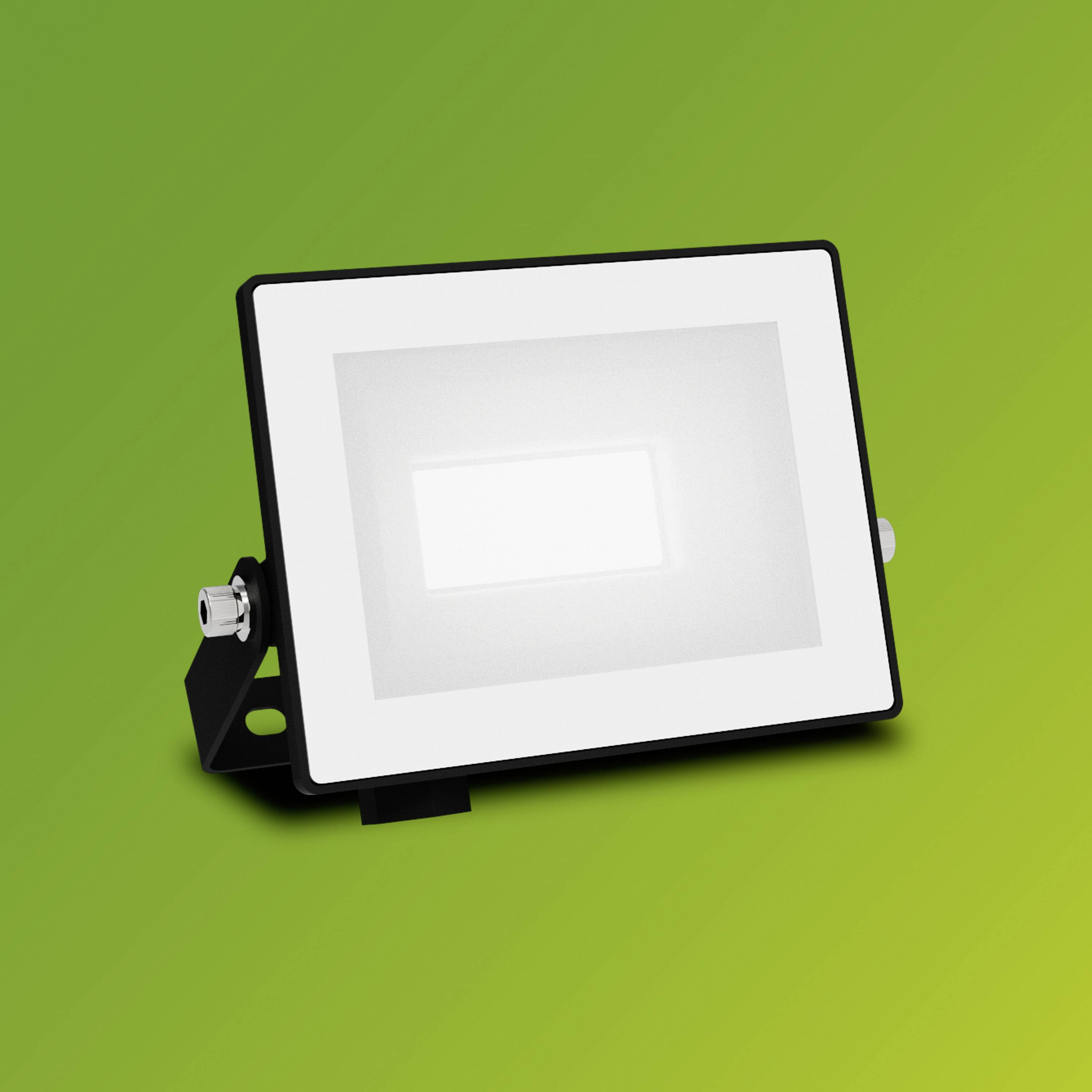 Ein rechteckiger LED-Strahler mit schwarzem Rahmen vor grünem Hintergrund, zeigt Beleuchtungstechnologie für den Außenbereich.