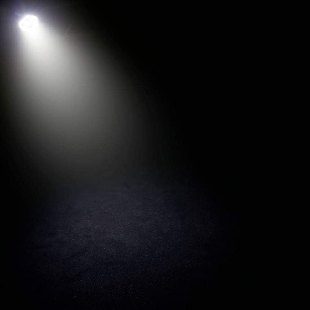 'Ein einzelner Lichtstrahl beleuchtet einen dunklen Raum, wobei das Licht allmählich in der Dunkelheit verblasst.'