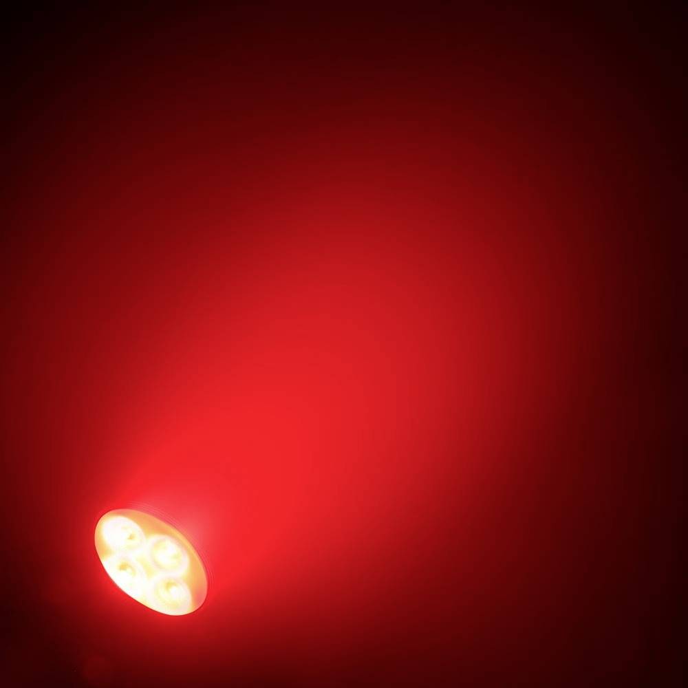 Eine leuchtende rote Taschenlampe strahlt Licht in einem dunklen Raum aus.