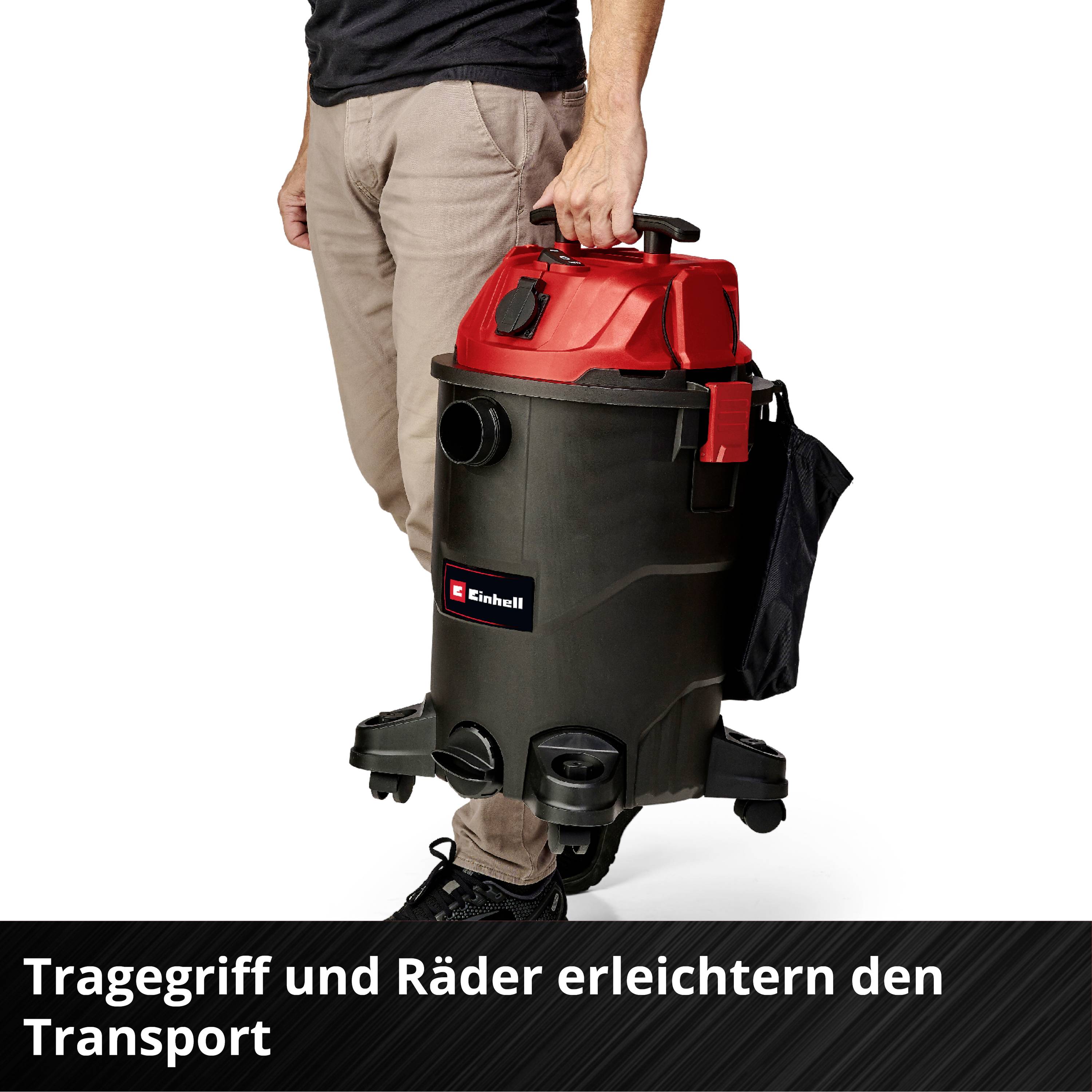 'Mann hält Industriesauger mit rotem Deckel und integriertem Tragegriff. Text im Bild: Tragegriff und Räder erleichtern den Transport.'