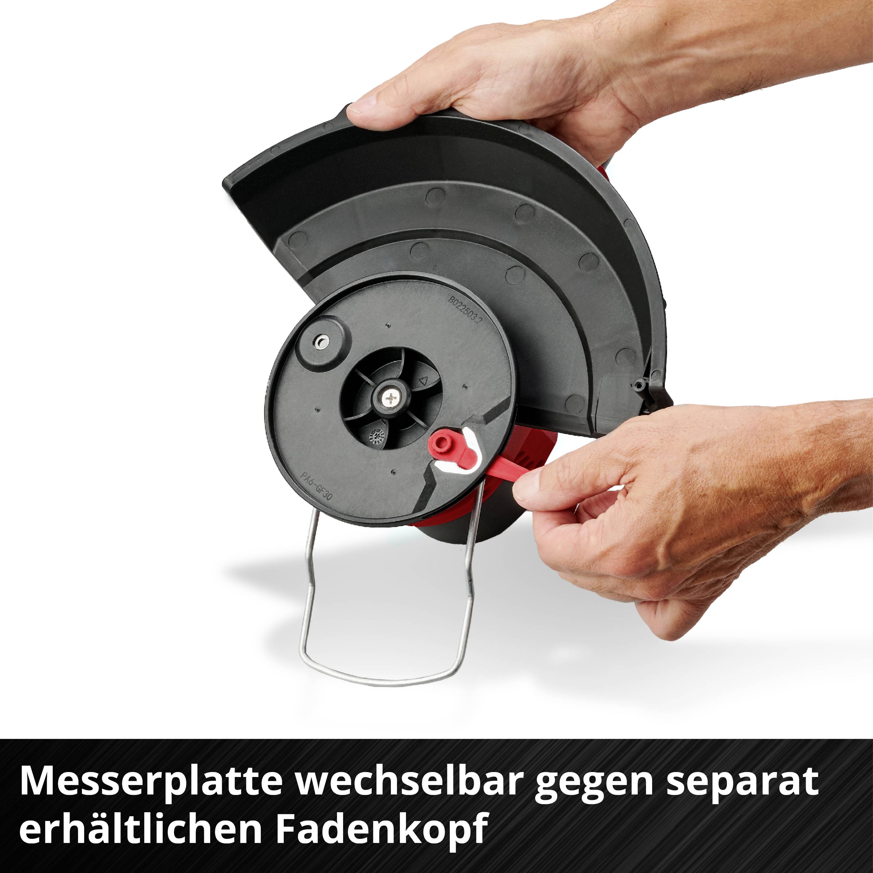 Eine Hand hält eine wechselbare Messerplatte einer Motorsense. Text: 'Messerplatte wechselbar gegen separat erhältlichen Fadenkopf'.