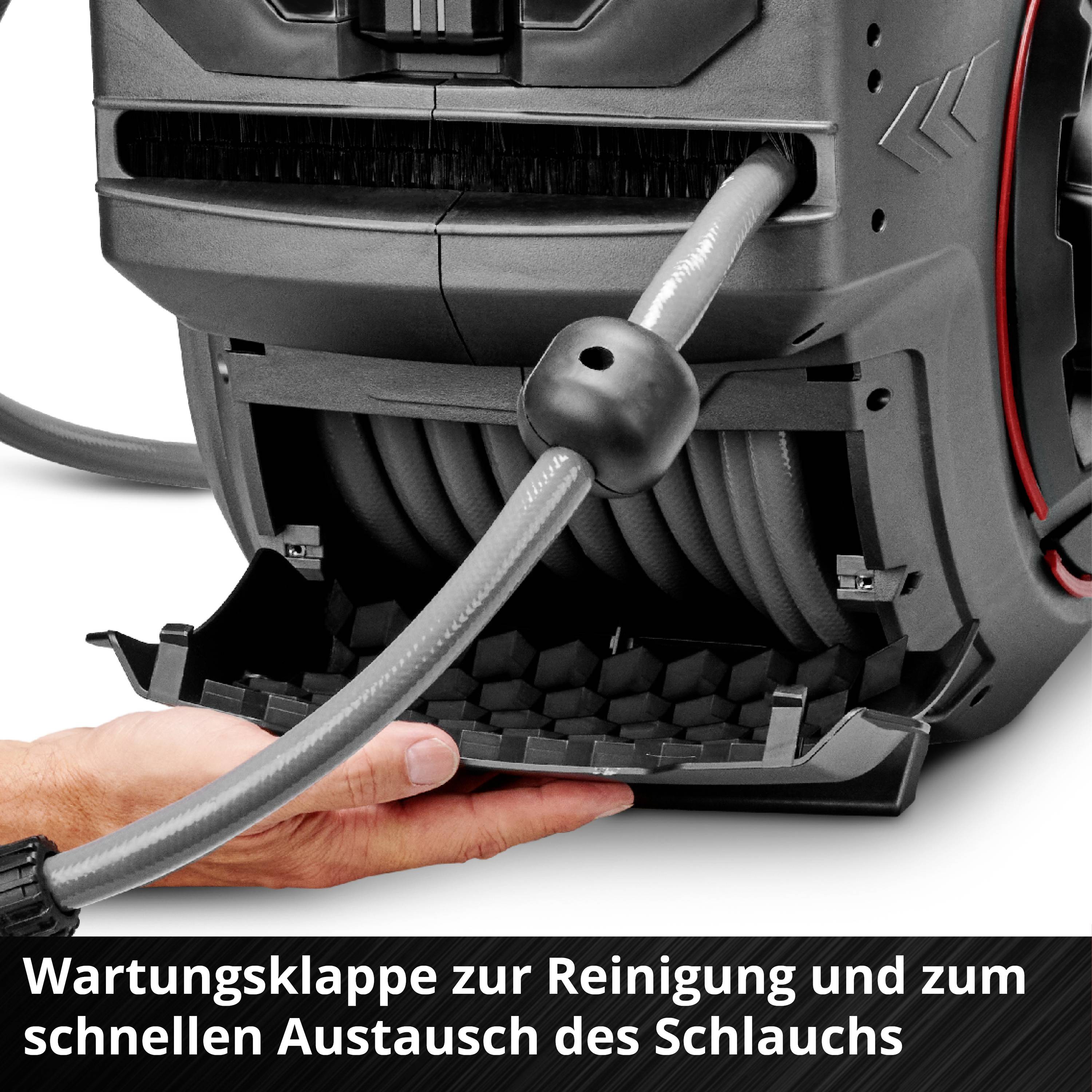 Eine Hand öffnet eine Wartungsklappe an einem Gerät zur Reinigung eines Schlauches.