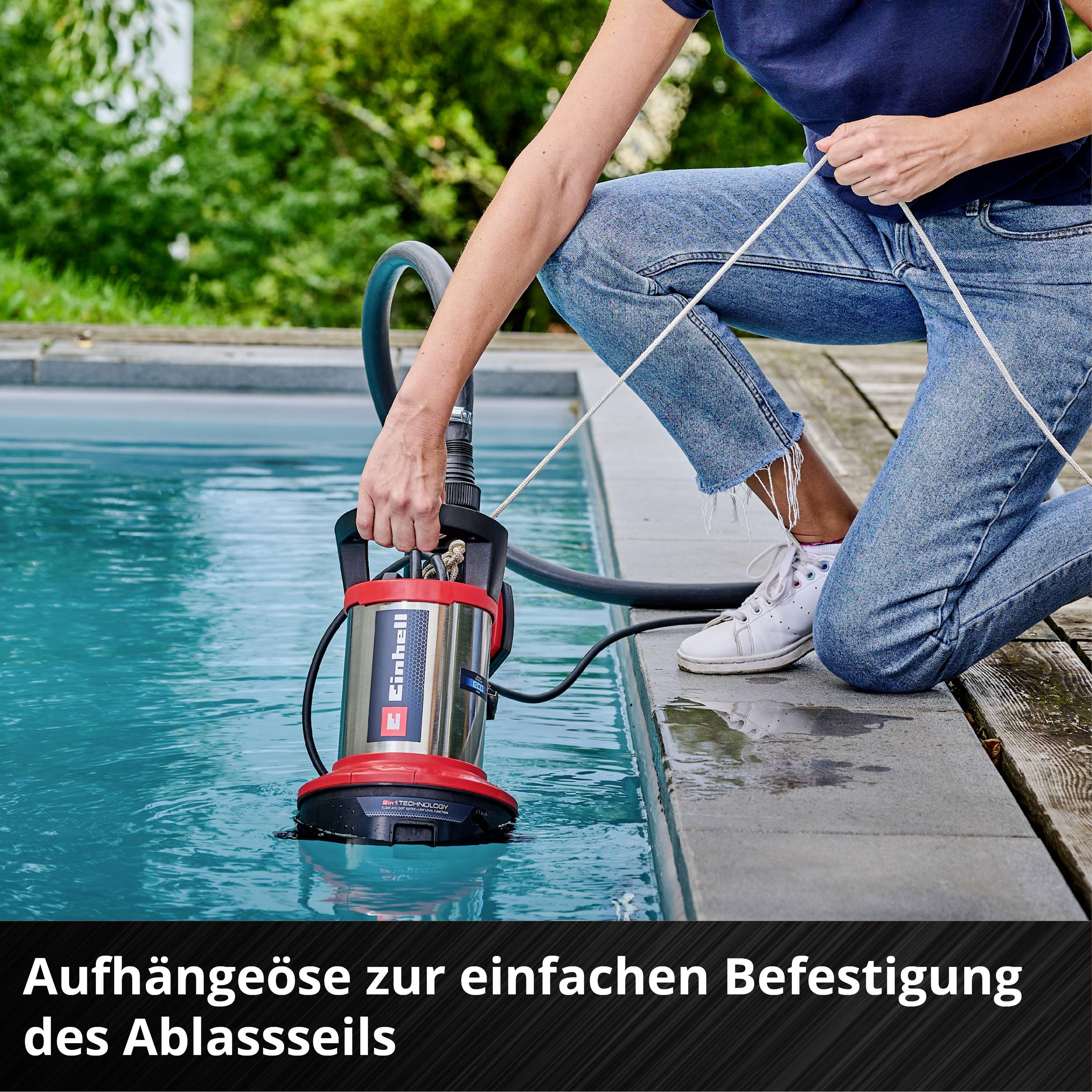 Person installiert eine Tauchpumpe in einem Swimmingpool. Unten steht 'Aufhängeöse zur einfachen Befestigung des Abhängeseils'.