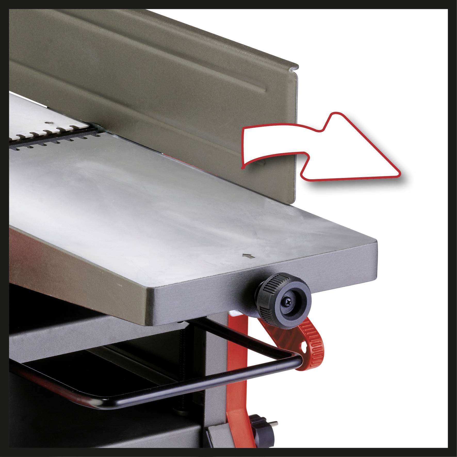 Metallische Tischplatte mit rotem Drehknopf zur Einstellung. Ein Pfeil zeigt auf den verstellbaren Teil der Tischplatte.