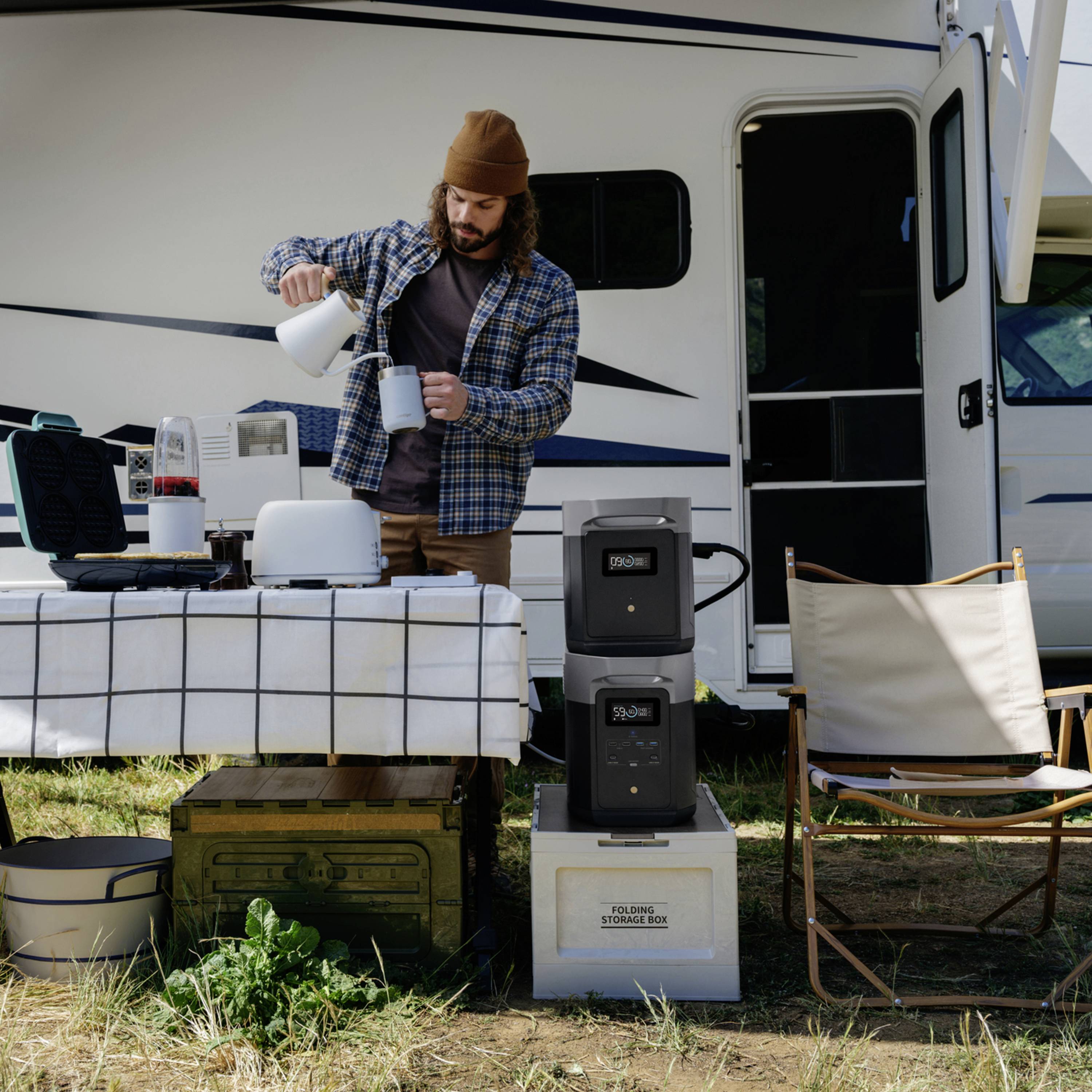Ein Mann gießt Kaffee an einem Tisch mit Campingausrüstung vor einem Wohnmobil. Neben ihm stehen Kühlgeräte und ein Wasserkanister.